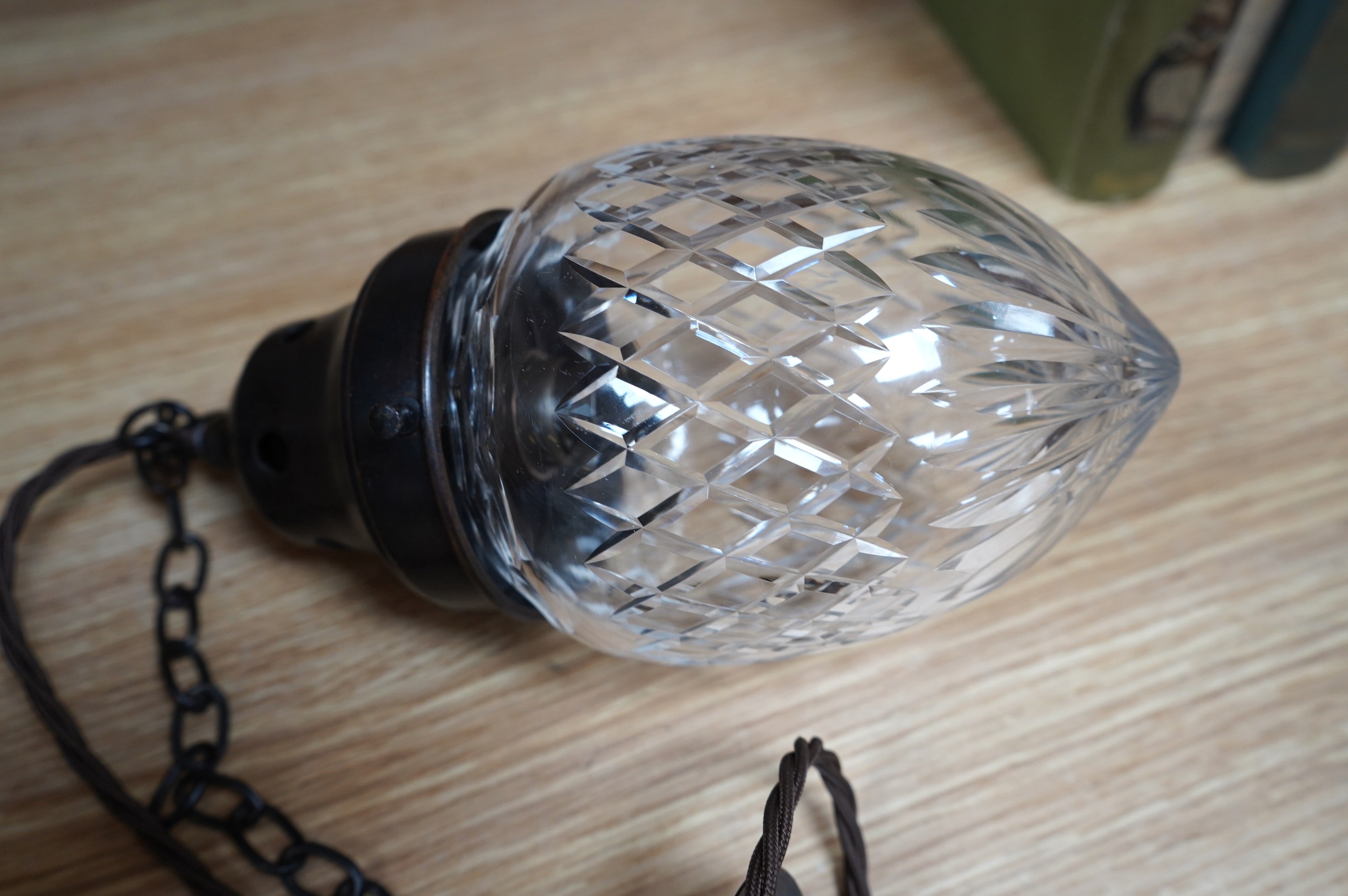 An English 1920’s crystal acorn pendant with gilded bronzed fitting, chain and ceiling rose, wired, glass including gallery 24cm high, 11cm across. Condition - good, not tested